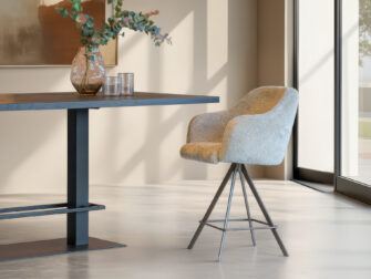 Luxe barkruk met zachte bekleding in neutrale tinten en ranke poten