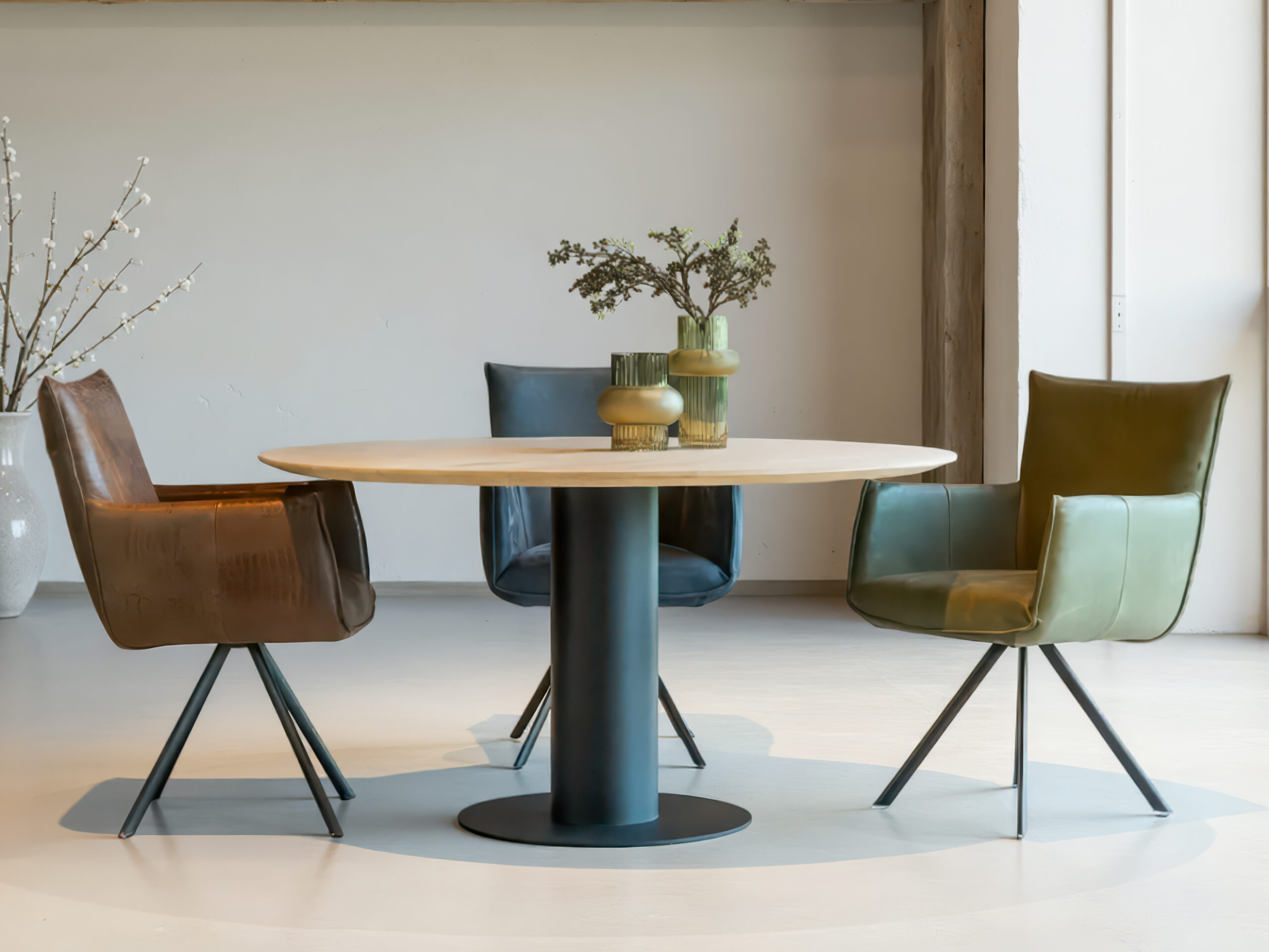 Set eetkamerstoelen in bruin en groen rond een houten eettafel