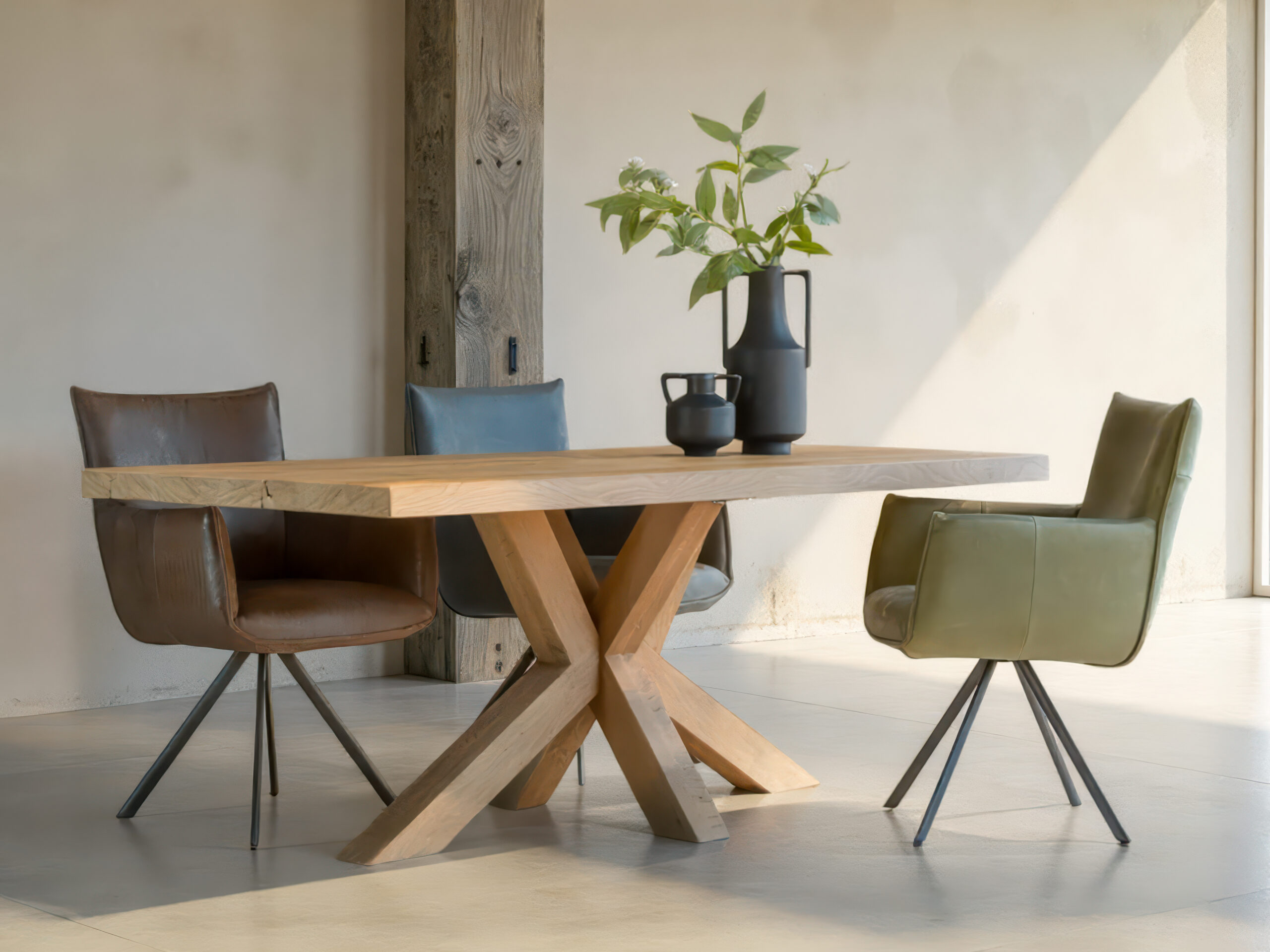 Comfortabele designstoelen in verschillende kleuren bij houten tafel