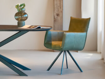 Moderne eetkamerstoel in groen leer met zwarte metalen draaipoot