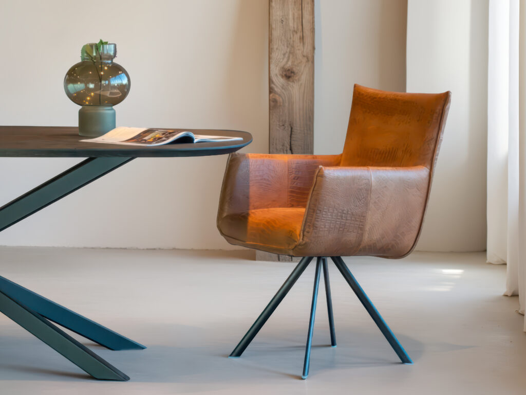 Cognac designstoel met comfortabele armleuningen en metalen frame