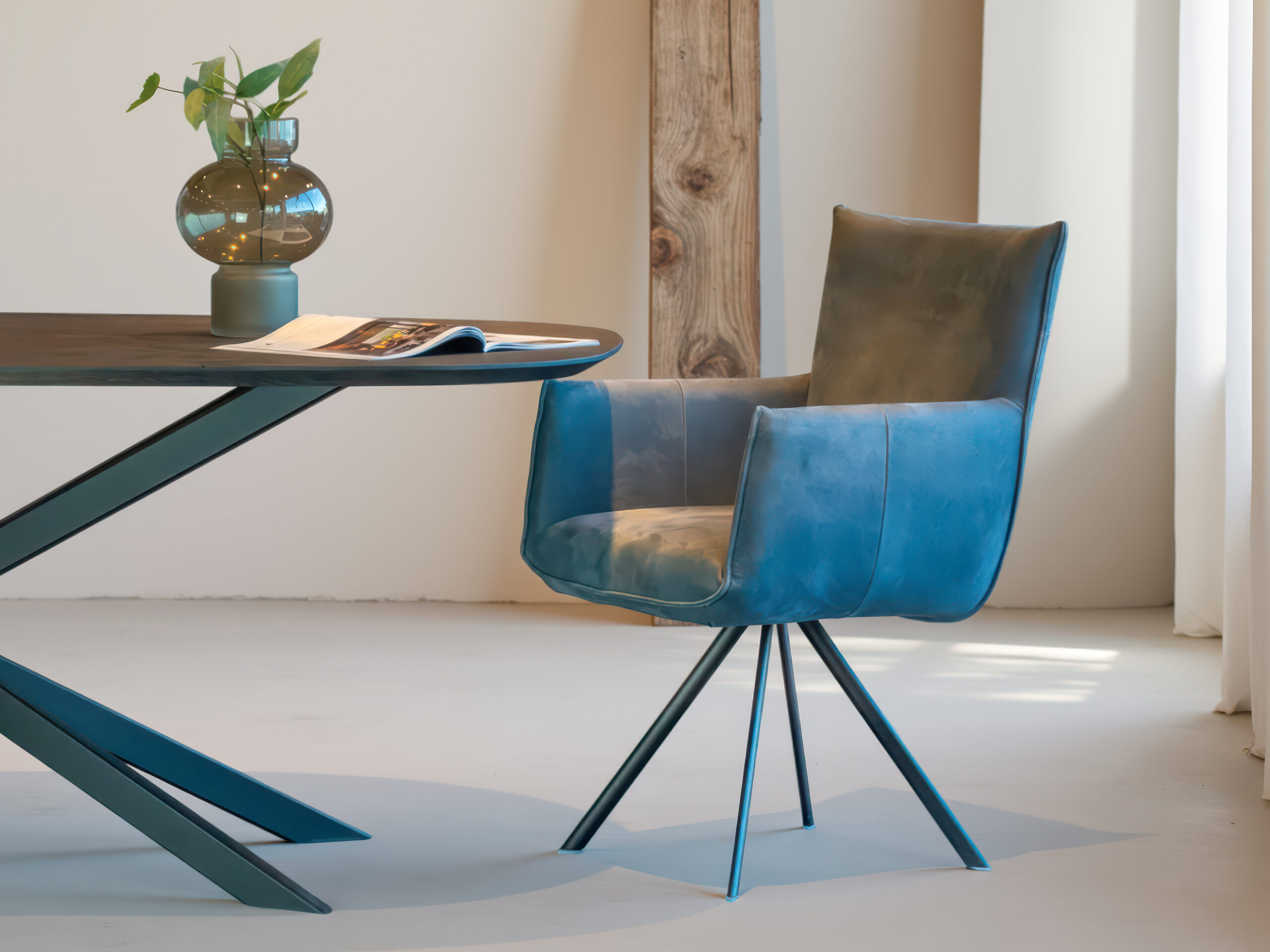 Comfortabele blauwe eetkamerstoel met elegante poten en armleuningen