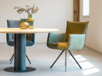 Designstoel in groen leer met armleuningen en draaibaar onderstel