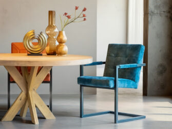 Donkerblauwe eetkamerstoel met armleuningen en stevig metalen frame