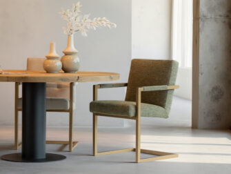 Donkergroene eetkamerstoel met strakke lijnen en metalen poten