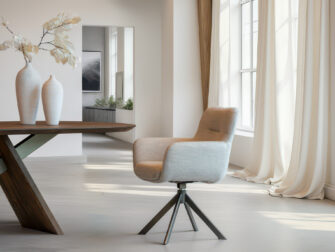 Eigentijdse eetkamerstoel met zachte stoffering en bruin kleurige stalen kruisvoet