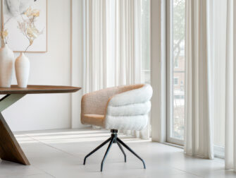 Design eetkamerstoel met fijne belijning, voorzien van draaibare zwart metalen spinpoot en een warme lichtbruine zitting