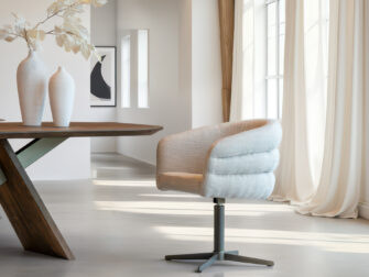 Luxe eetkamerstoel met moderne kruispoot in anodic bruin metaal, afgewerkt met een comfortabele zitting in licht taupe stof