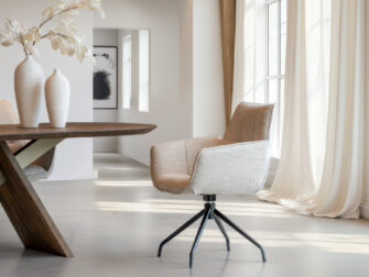 Elegante stoel met beige zitvlak en matzwart metalen frame met kruisvormig onderstel