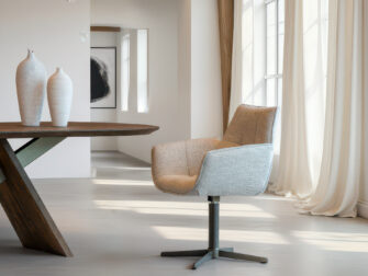 Moderne eetkamerstoel met zachte zandkleurige bekleding en een anodic bruin draaibaar steronderstel