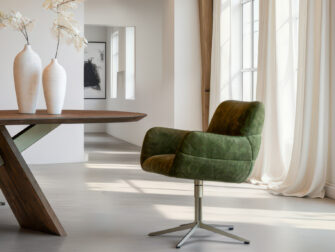 Diepgroene fluwelen eetkamerstoel met armleuningen en een brede draaivoet