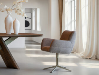 Eetkamerstoel met diepe zit in taupe kleurige stof en licht metalen kruisframe