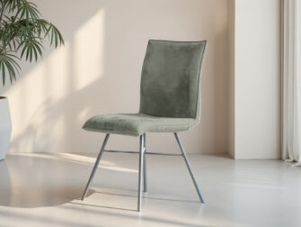 Lichtgroene eetkamerstoel met zwart kruisframe en zachte suède bekleding