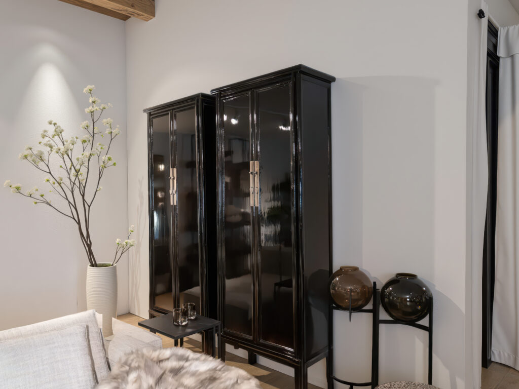 hoge vitrinekasten van oud Chinees hout met een glanzende afwerking en elegante deuren