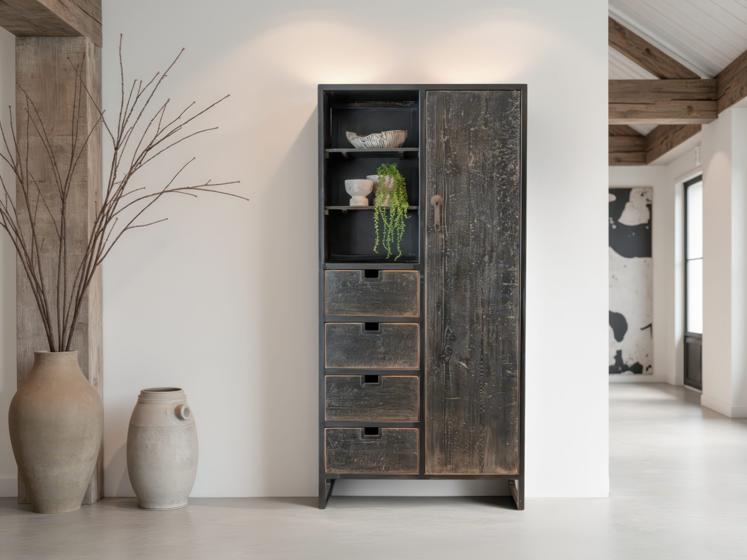 Robuuste houten kast in verweerd zwart met speelse indeling van lades en een hoge deur