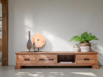 Laag houten tv-meubel met vijf lades en een open vak in het midden, afgewerkt in natuurlijk hout met robuuste poten