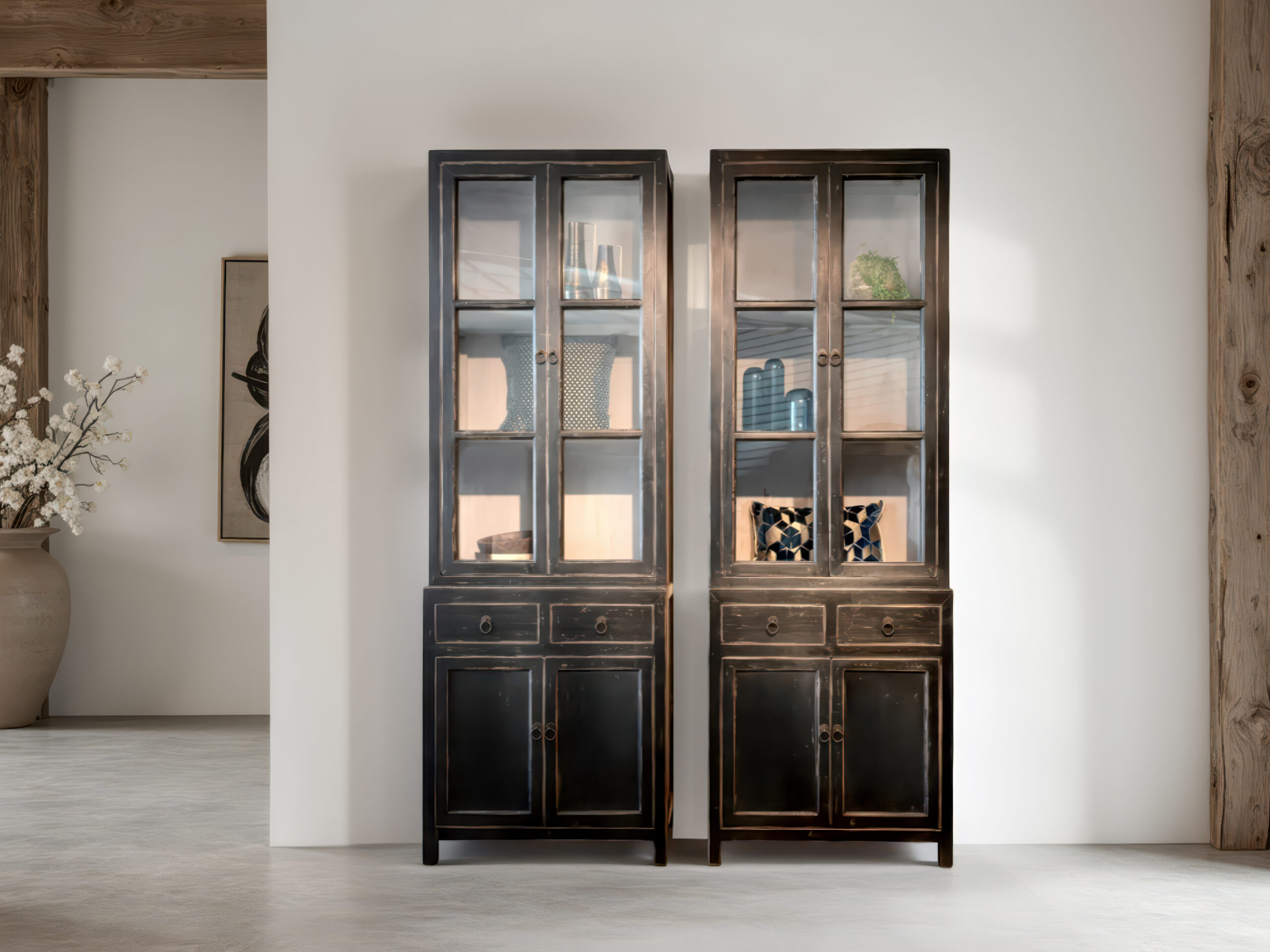 landelijke vitrinekast van zwart hout met glazen deuren en sierlijke details