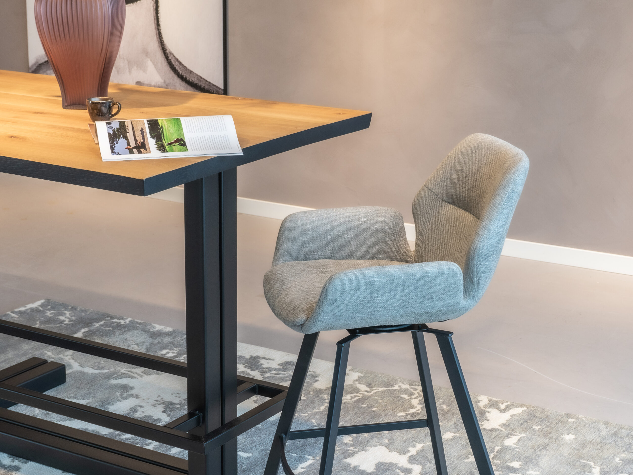 Taupe barkruk met een comfortabele zitting en moderne uitstraling.