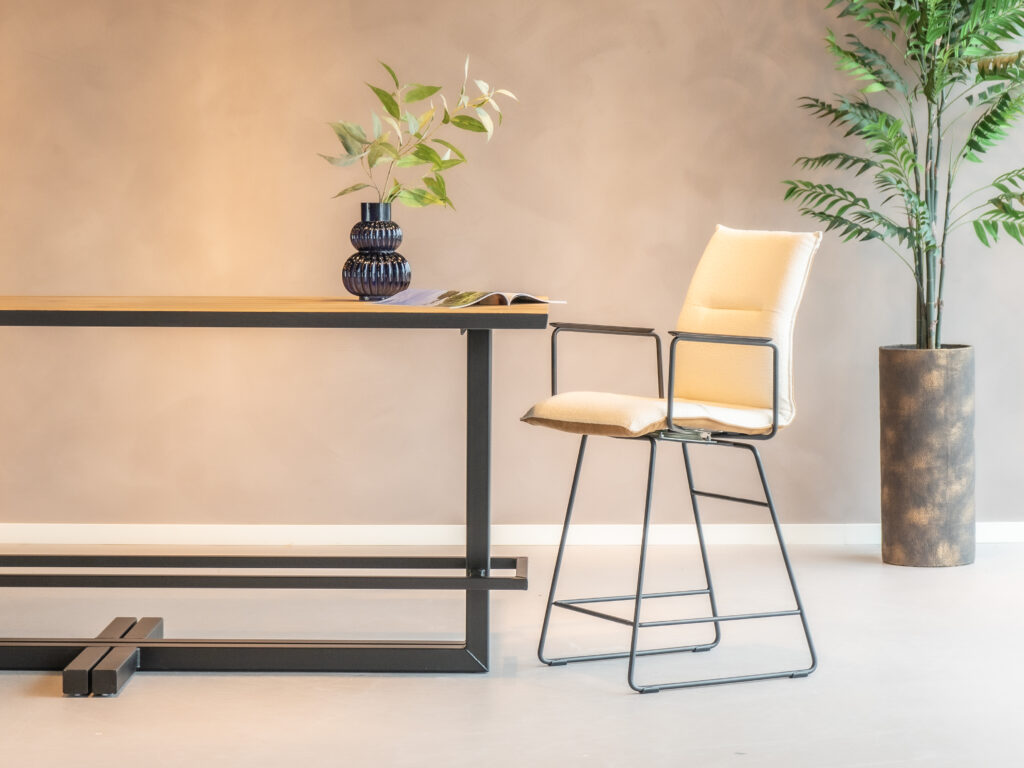 Barkruk Remy met arm is een luxe zitoptie met een achterkant in africa caramel en een voorkant in alpine ivory, ideaal voor een chique bar of keuken.