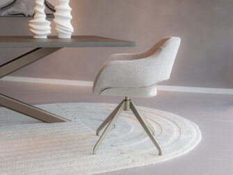 Eetkamerstoel in beige met zachte stof en champagne draaipoot