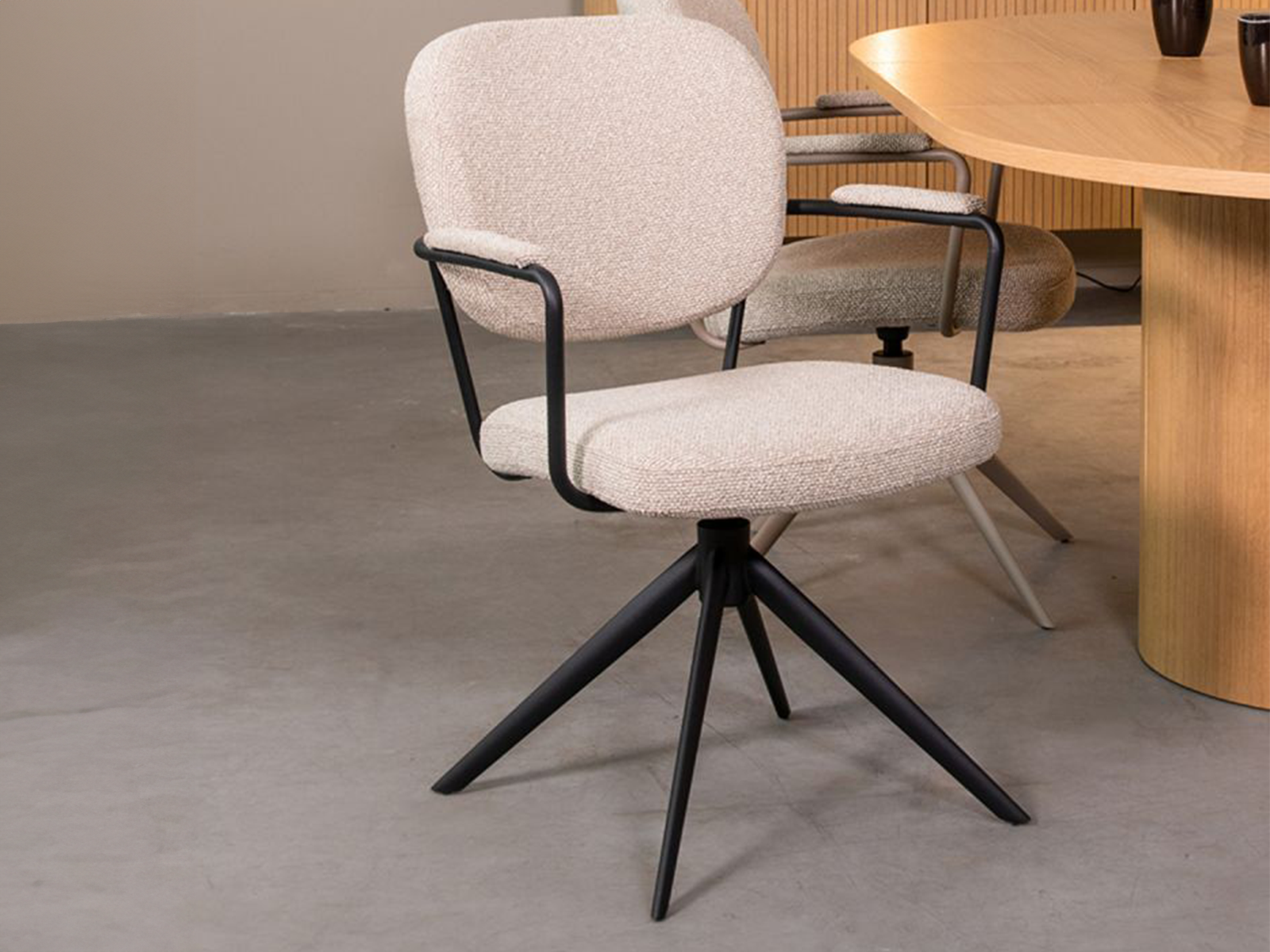 Eetkamerstoel in naturel Boucle met armleuningen en een zwart metalen onderstel