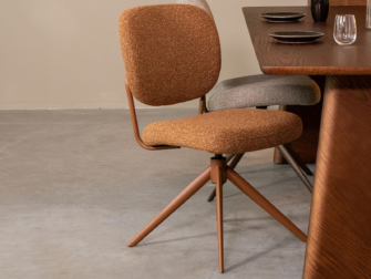 Moderne eetkamerstoel met warme Boucle bekleding en draaibare terrakleurige poten