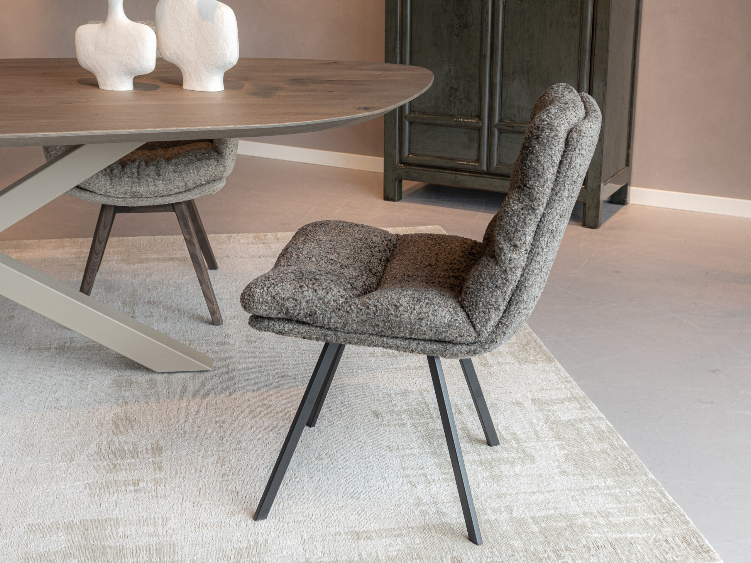 Modern vormgegeven eetstoel met slank frame en zachte bekleding