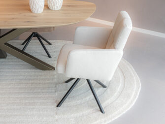 Cremekleurige eetkamerstoel met rugstiksel en zwarte draaipoot