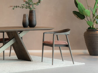 moderne eetkamerstoel met warme houttinten en een chique roze gestoffeerde zitvlak