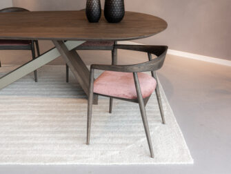 handgemaakte houten eetkamerstoel met open rugontwerp en roze beklede zitting