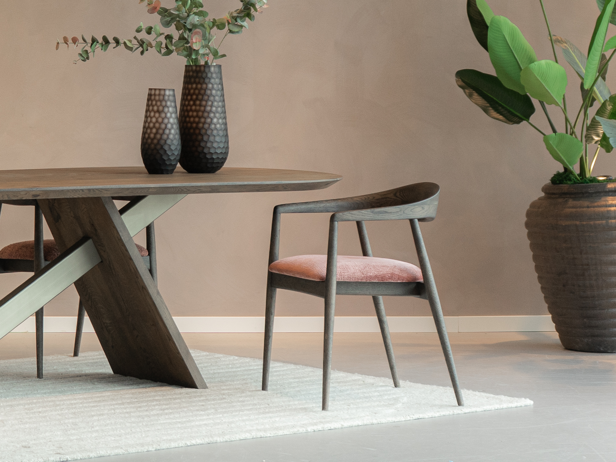 sfeervolle eetkamerstoel met een klassieke houten look en een moderne roze zitting