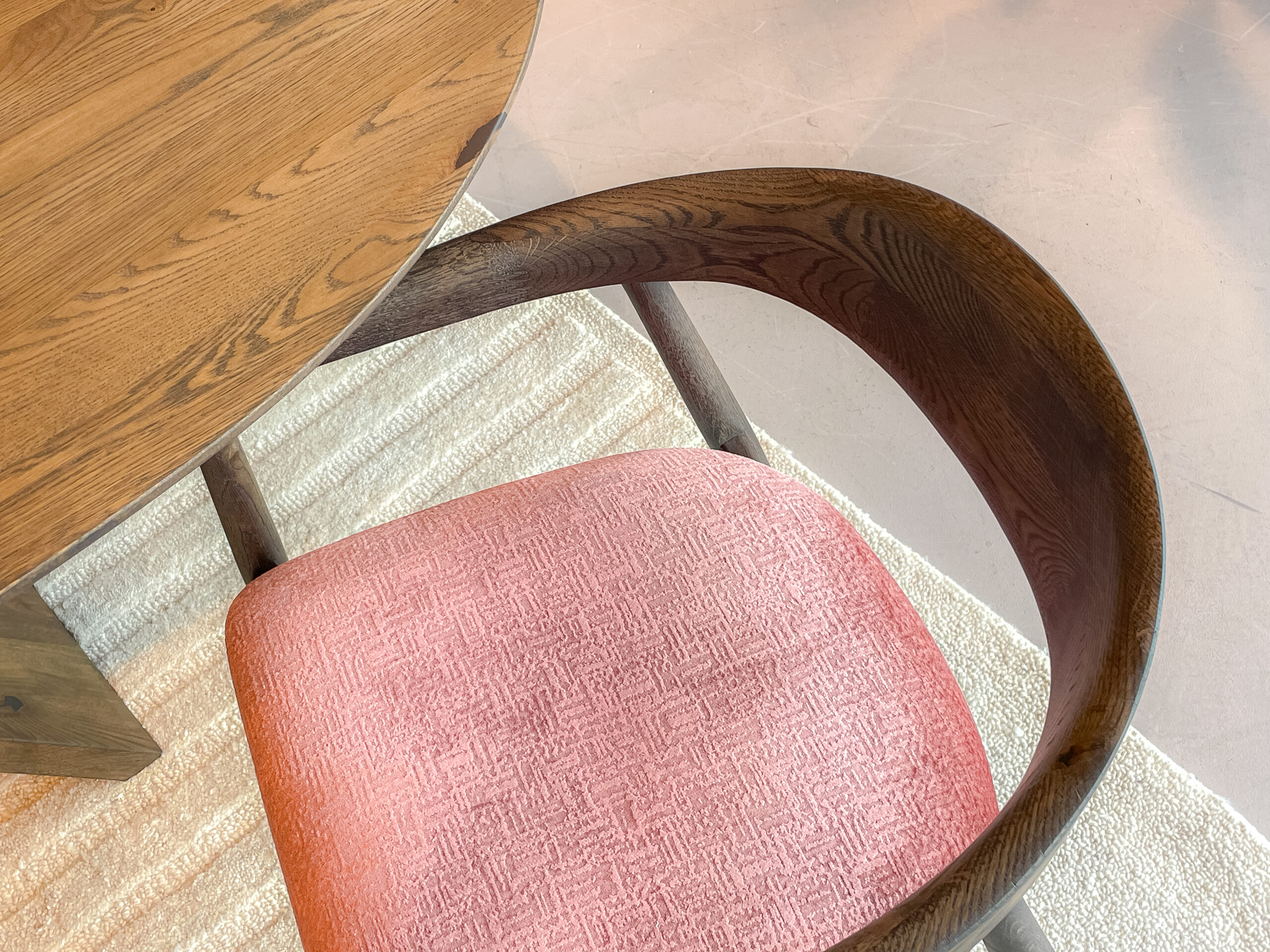 elegant eetkamerstoel met donkerbruine houten poten, open halfronde rugleuning en roze gestoffeerde zitting