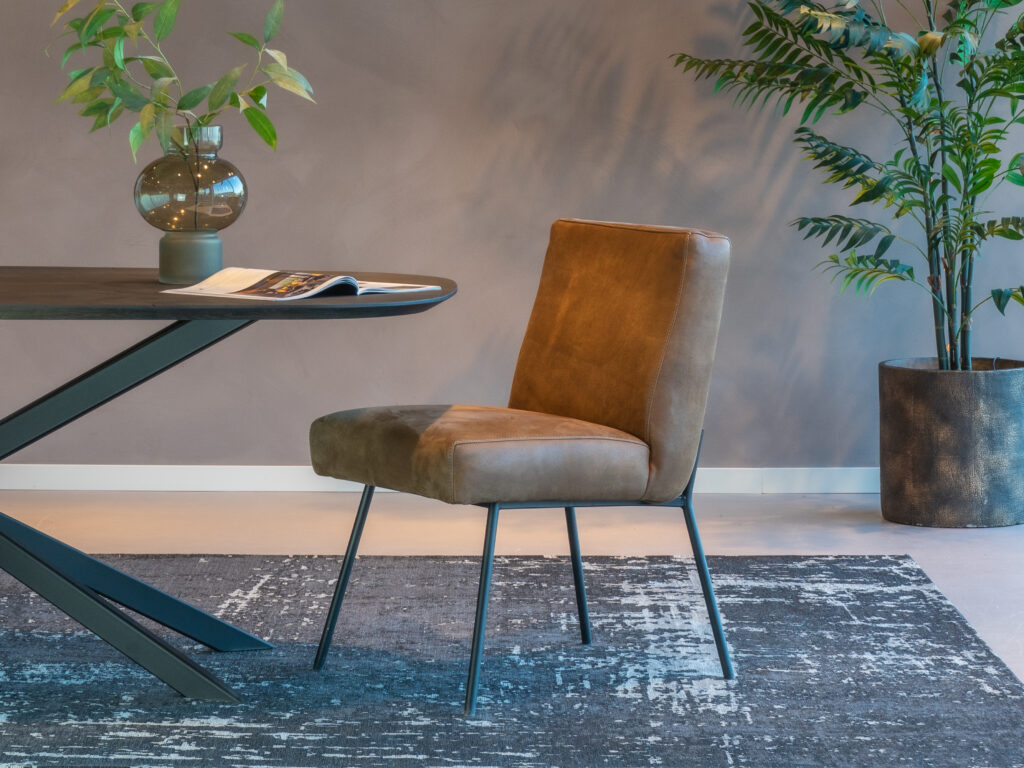 Leren bruine eetkamerstoel met zachte zit en zwart frame