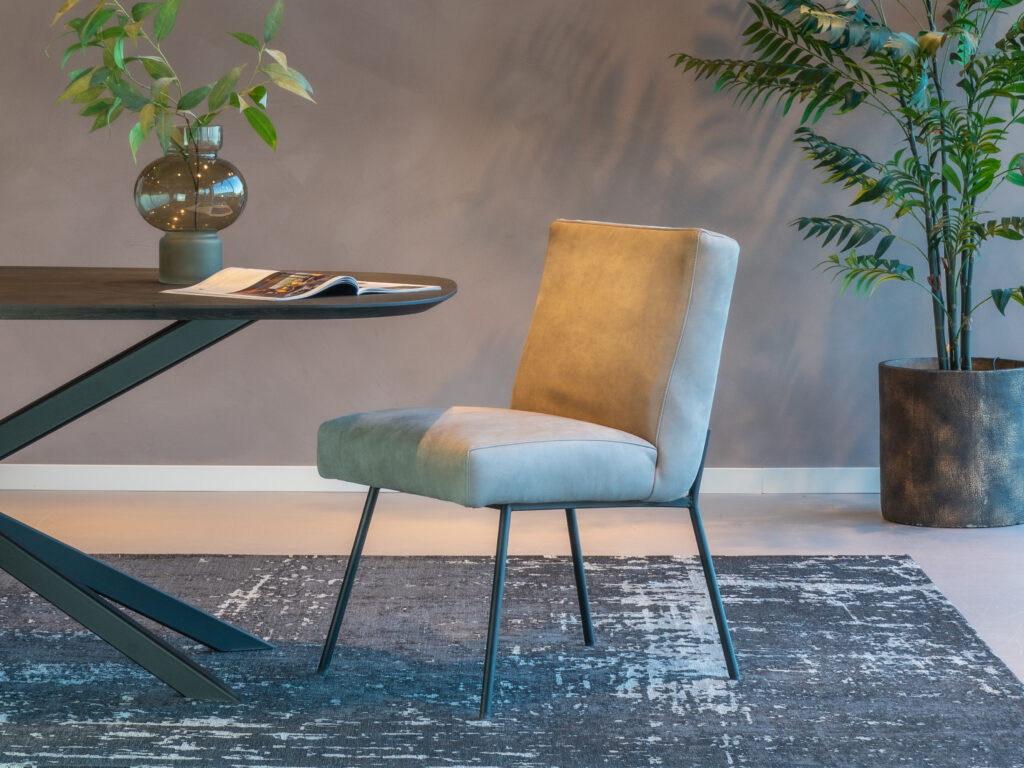 Comfortabele eetkamerstoel in een licht grijze luxe leersoort met zwarte pootjes