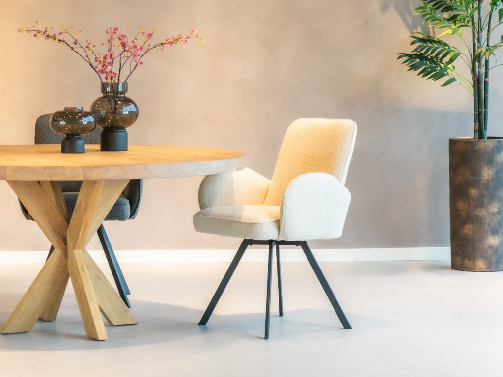 Beige eetkamerstoel met een modern ontwerp en zwarte poten.