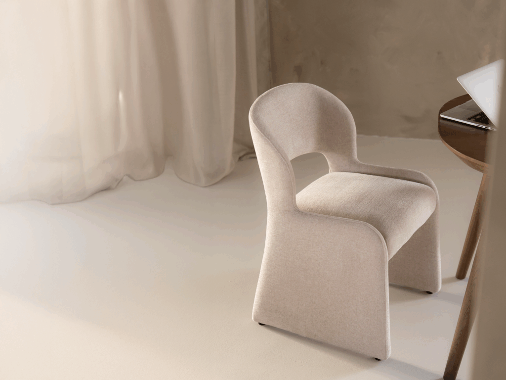 Moderne gestoffeerde stoel met ronde rugleuning en strakke vormen