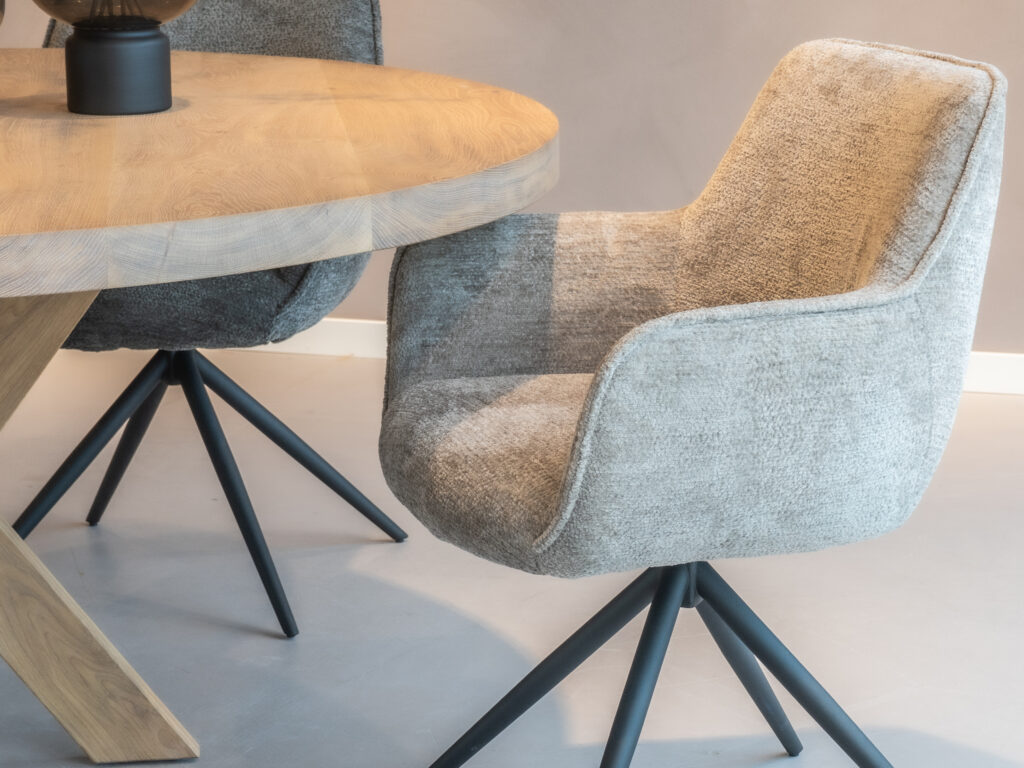 Beige eetkamerstoel met een stijlvol ontwerp en zwarte poten.