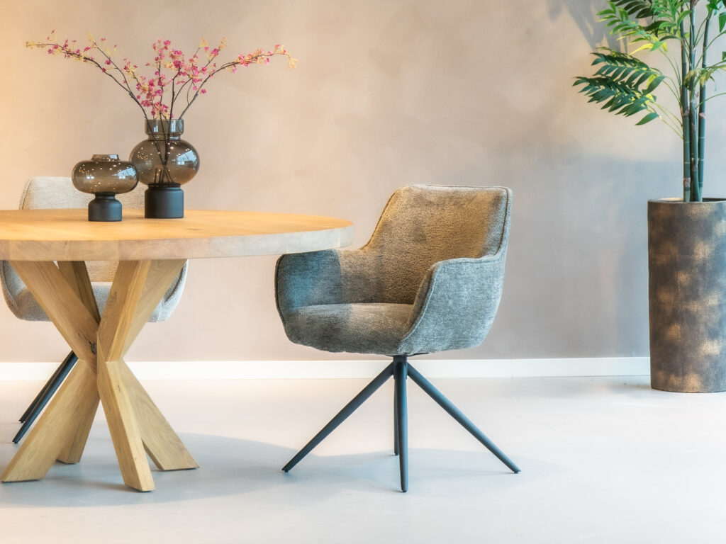 Grijze eetkamerstoel met een strak design en zwarte poten.