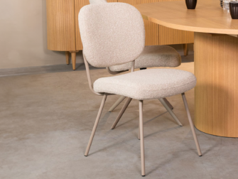 lichtkleurige eetkamerstoel zonder armleuningen, met zacht Boucle zitvlak en metalen poten