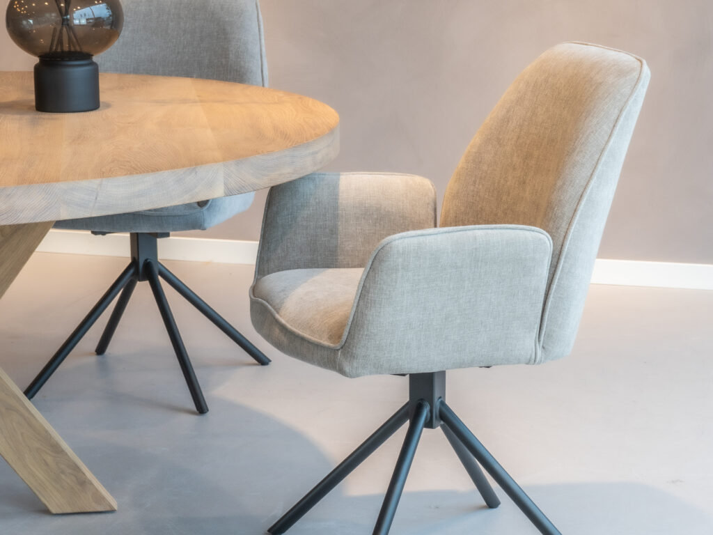 Beige-grijze eetkamerstoel met een eigentijds ontwerp en zwarte poten.
