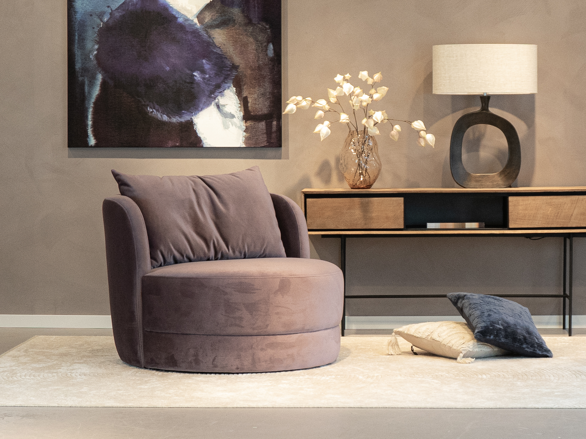 Lila kleurige fauteuil met een ronde vorm en brede zitting