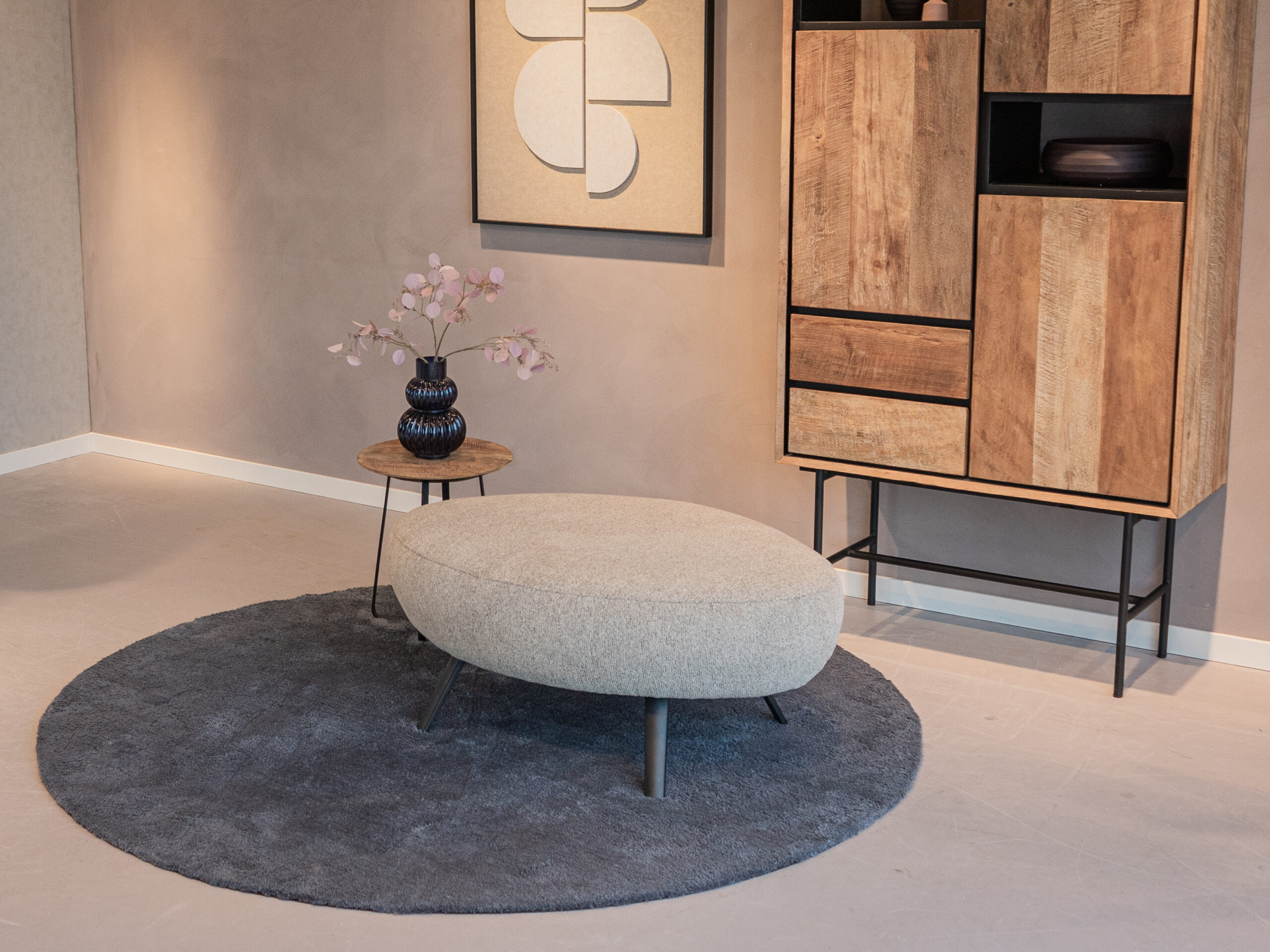 losse hocker met vloeiende lijnen, geschikt als voetenbank of extra zitplaats