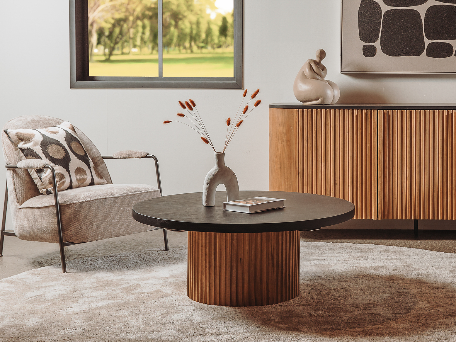 Ronde salontafel met een teakhouten geribbelde cilindervoet en donker houten blad