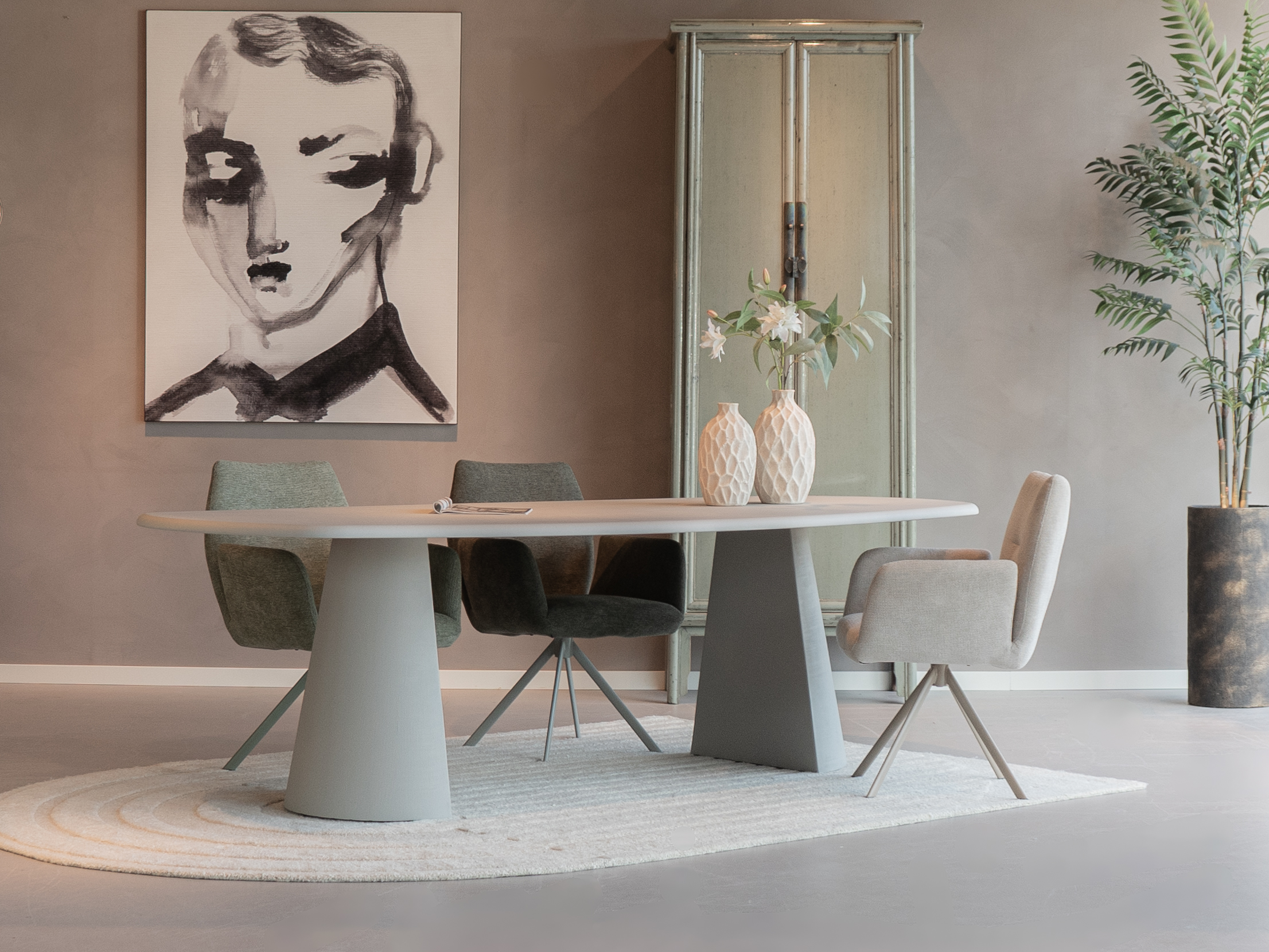 eettafel van beton in de vorm deens ovaal met eetkamerstoelen