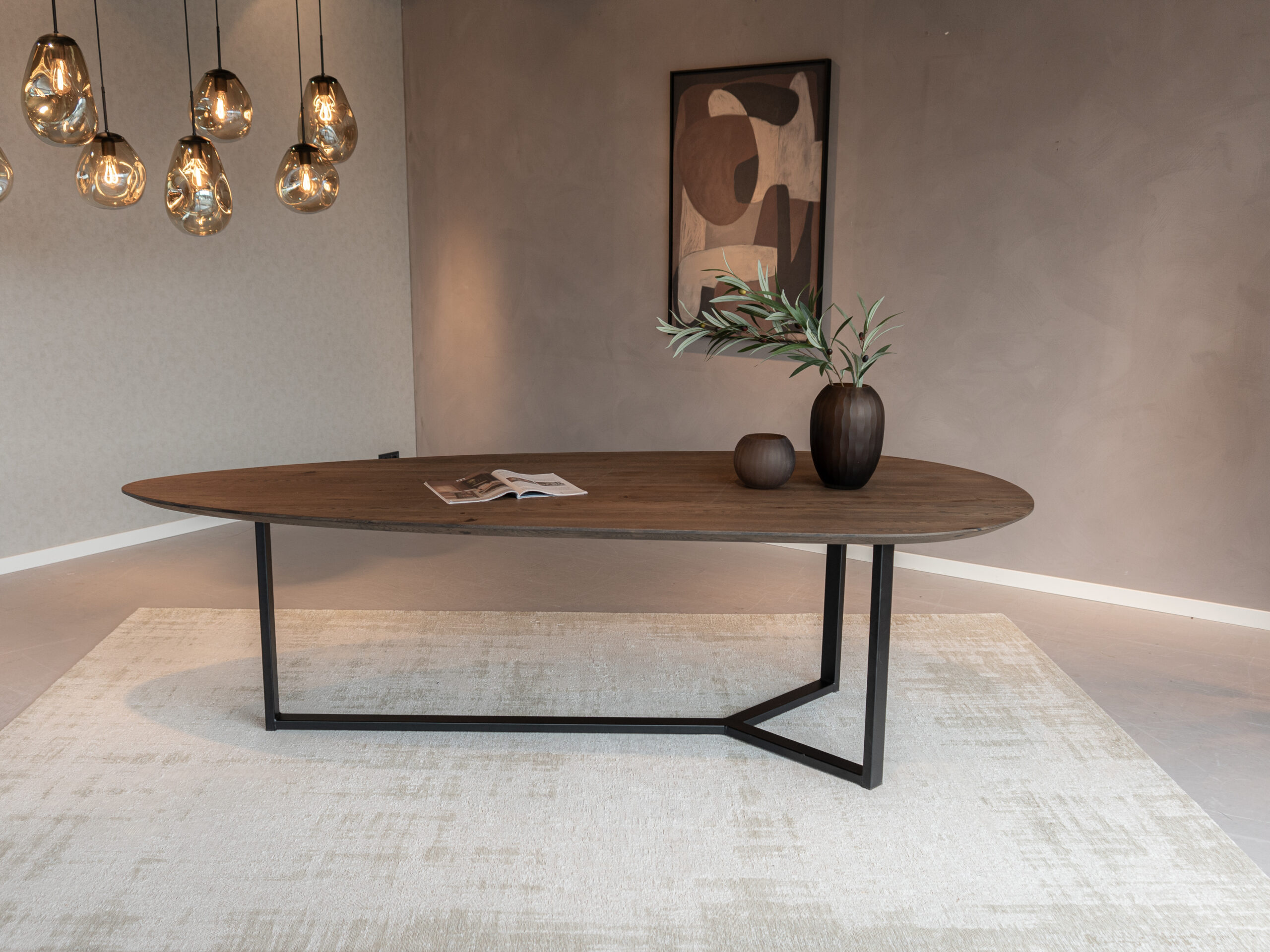 Druppelvormige eetkamertafel met warme houtstructuur en verfijnd stalen design