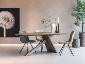 Druppelvormige 'Constance' eettafel vergezeld van elegante Trevano eetkamerstoelen in een lichte ruimte.